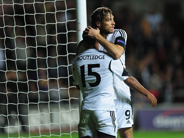 Swansea's Wayne Routledge is congratulated by teammate Michu after scoring the opening goal against St Gallen during their Europa League group match on October 3, 2013