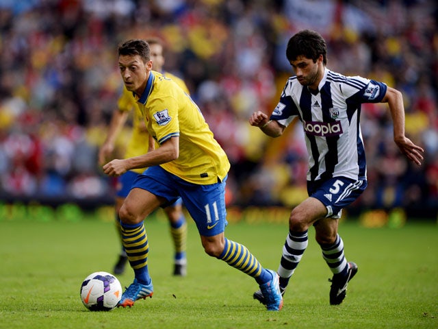 Mesut Ozil of Arsenal is chased by Claudio Yacob of West Bromwich Albion during the Barclays Premier League match between West Bromwich Albion and Arsenal at The Hawthorns on October 6, 2013
