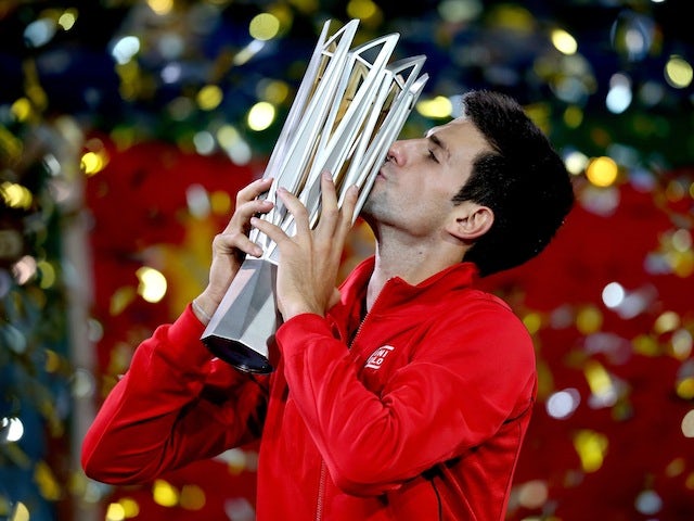 Novak Djokovic of Serbia poses for photographers with the winner's trophy after defeating Juan Martin Del Potro of Argentina in the Shanghai Masters final on October 13, 2013