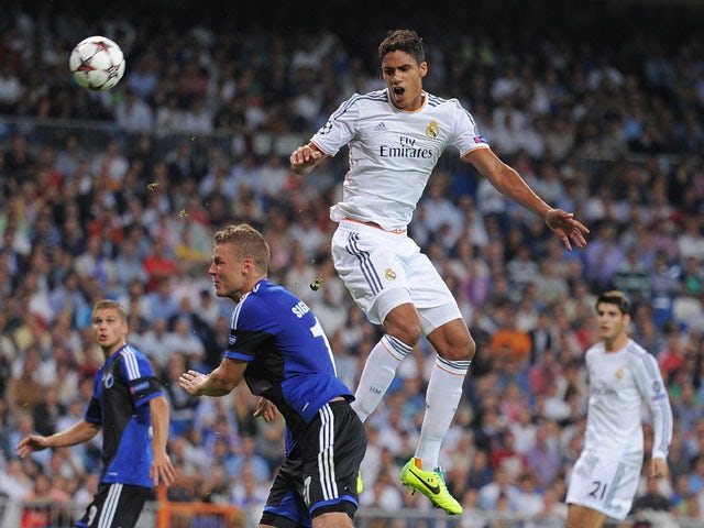 Raphael Varane of Real Madrid CF heads the ball beside Ragnar Sigurdsson of FC Copenhagen during the UEFA Champions League match between Real Madrid CF and FC Copenhagen at Estadio Santiago Bernabeu on October 2, 2013