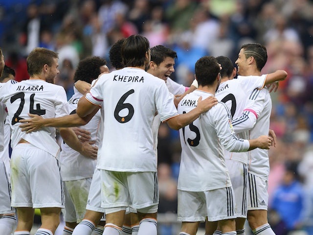 Real Madrid's Portuguese forward Cristiano Ronaldo celebrates with teammates after scoring during the Spanish league football match Real Madrid vs Malaga on October 19, 2013