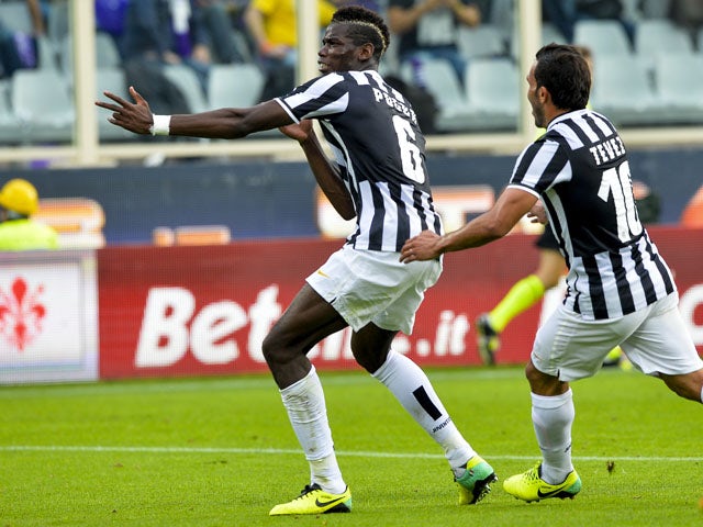 Juventus' French midfielder Paul Labile Pogba celebrates with teammate Carlo Tevez after scoring during the Italian Serie A football match Fiorentina vs Juventus on October 20, 2013