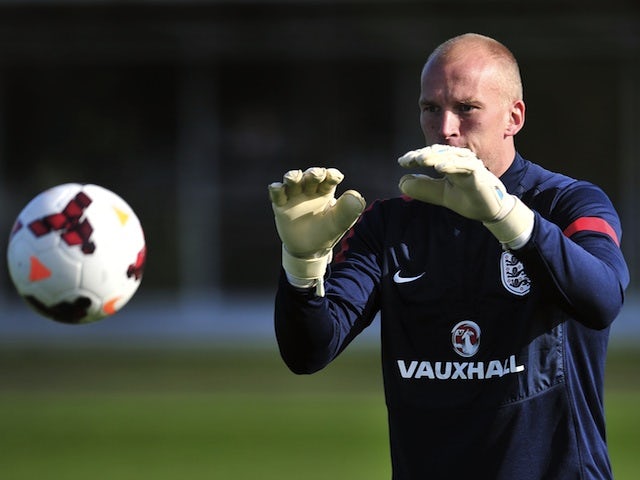 England goalkeeper John Ruddy catches the ball during a training session at London Colney on October 10, 2013