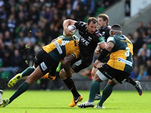 Joe Bearman of Ospreys is tackled by Courtney Lawes and Salesi Ma'Afu of Northampton Saints during the Heineken Cup Round 2 match between Northampton Saints and Ospreys at Franklin's Gardens on October 20, 2013