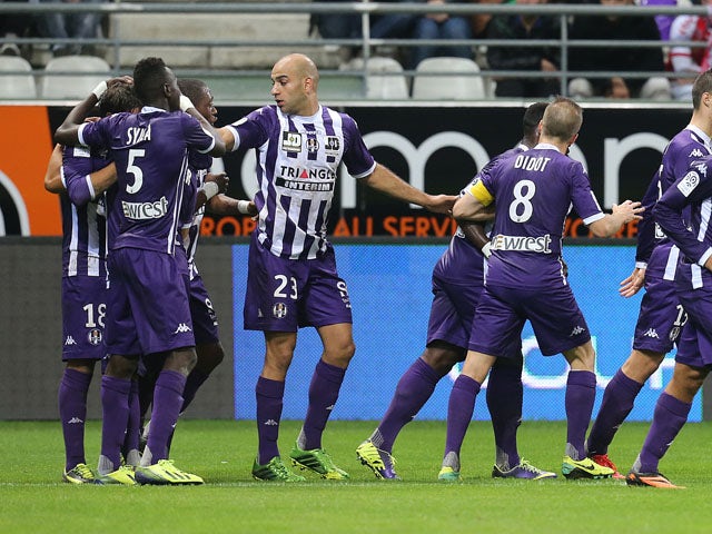 Toulouse's teammates celebrate after Oscar Trejo scored a goal during the French L1 football match Reims vs Toulouse on October 18, 2013