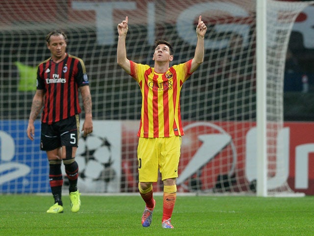 Lionel Messi of FC Barcelona celebrates scoring the first goal during the UEFA Champions League Group H match between AC Milan and Barcelona at Stadio Giuseppe Meazza on October 22, 2013