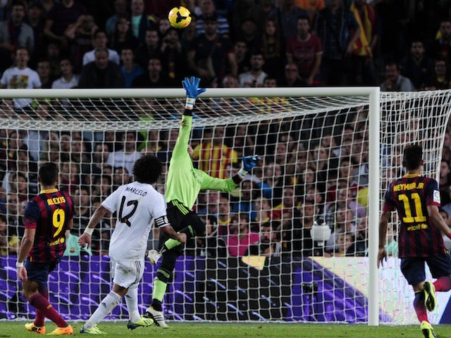 Barcelona's Chilean forward Alexis Sanchez scores past Real Madrid's goalkeeper Diego Lopez during the Spanish league Clasico football match FC Barcelona vs Real Madrid CF on October 26, 2013