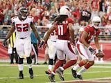 Wide receiver Michael Floyd #15 of the Arizona Cardinals looks over to Larry Fitzgerald #11 after catching a 15 yard touchdown reception against the Atlanta Falcons during the second quarter of the NFL game at the University of Phoenix Stadium on October 