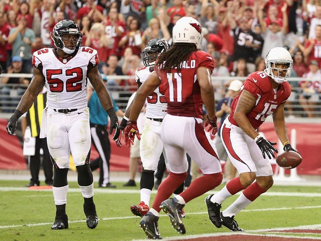 Wide receiver Michael Floyd #15 of the Arizona Cardinals looks over to Larry Fitzgerald #11 after catching a 15 yard touchdown reception against the Atlanta Falcons during the second quarter of the NFL game at the University of Phoenix Stadium on October 