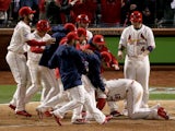 The St. Louis Cardinals surround Allen Craig #21 after he scored the winning run against the Boston Red Sox in the ninth inning during Game Three of the 2013 World Series at Busch Stadium on October 26, 2013