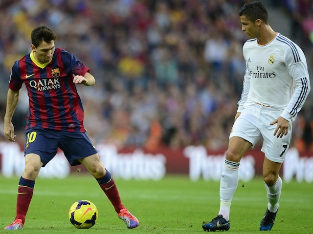 Barcelona's Argentinian forward Lionel Messi vies with Real Madrid's Portuguese forward Cristiano Ronaldo during the Spanish league Clasico football match on October 26, 2013