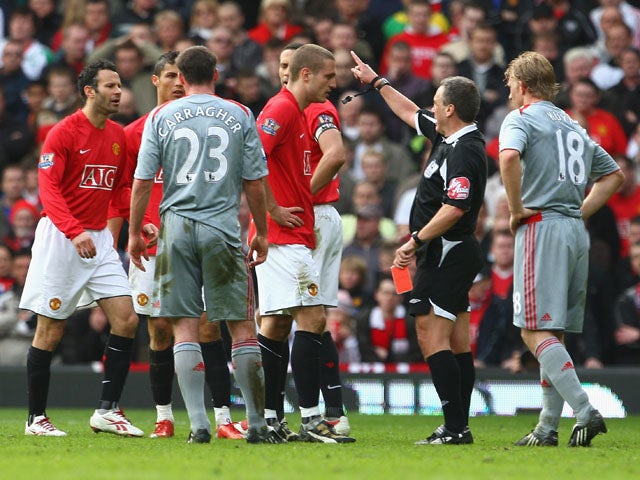 Referee Alan Wiley shows a red card to Nemanja Vidic of Manchester United during the Barclays Premier League match between Manchester United and Liverpool at Old Trafford on March 14, 2009