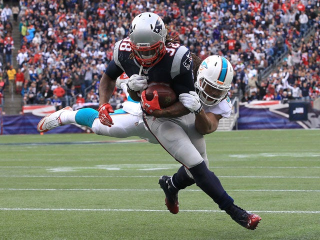 Brandon Bolden #38 of the New England Patriots scores as Philip Wheeler #52 of the Miami Dolphins attempts to defend in the second half at Gillette Stadium on October 27, 2013