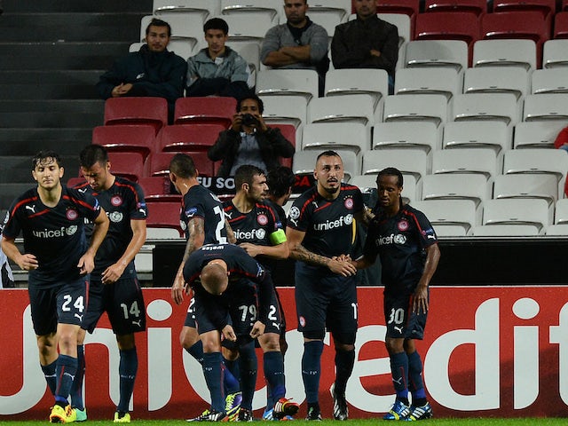 Olympiacos' players celebrate their first goal during the UEFA Champions League group C football match SL Benfica vs Olympiacos FC at Luz Stadium in Lisbon on October 23, 2013