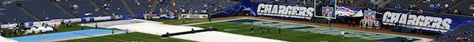 The grounds crew pulls back the rain soaked tarps on the field before the AFC Wild Card game between the San Diego Chargers and the New York Jets at Qualcomm Stadium on January 8, 2005