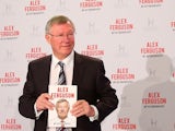 Former Manchester United manager Sir Alex Ferguson poses with his autobiography on October 22, 2013