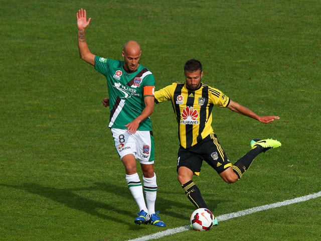 Vince Lia of the Phoenix passes around Ruben Zadkovich of the Jets during the round three A-League match between Wellington Phoenix and the Newcastle Jets at McLean Park on October 27, 2013