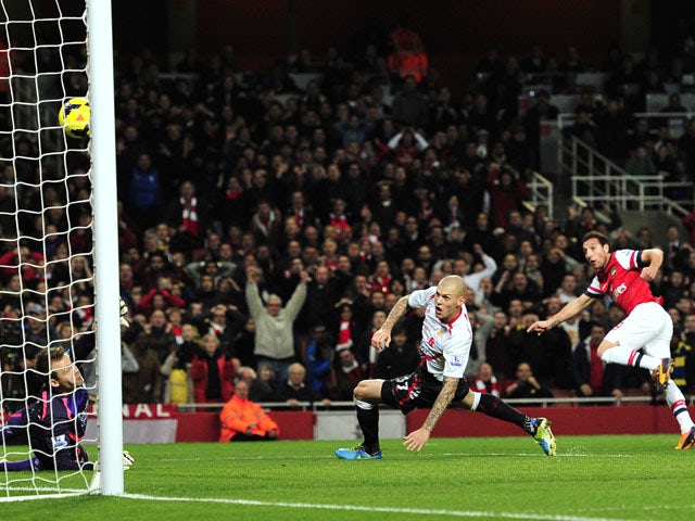 Arsenal's Spanish midfielder Santi Cazorla scores the opening goal during the English Premier League football match between Arsenal and Liverpool at the Emirates Stadium in north London, on November 2, 2013