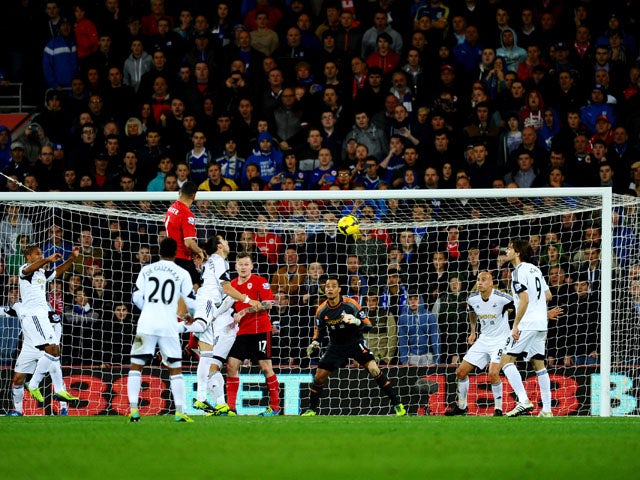 Steven Caulker of Cardiff City rise highest to score their first goal with a header during the Barclays Premier League match between Cardiff City and Swansea City at Cardiff City Stadium on November 3, 2013
