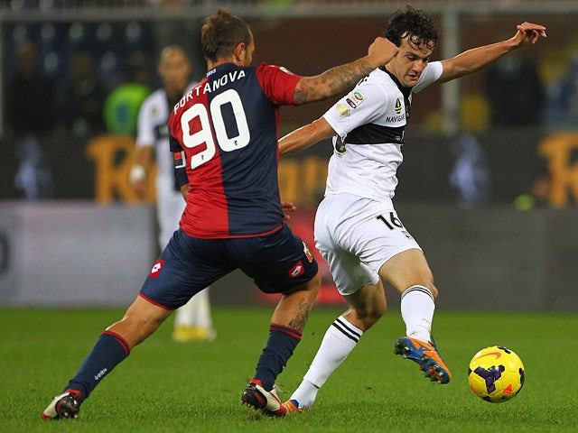 Genoa's Daniele Portanova and Parma's Marco Parolo battle for the ball on October 30, 2013