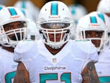 Mike Pouncey of the Miami Dolphins leads the team onto the field during a preseason game against the Jacksonville Jaguars at EverBank Field on August 9, 2013