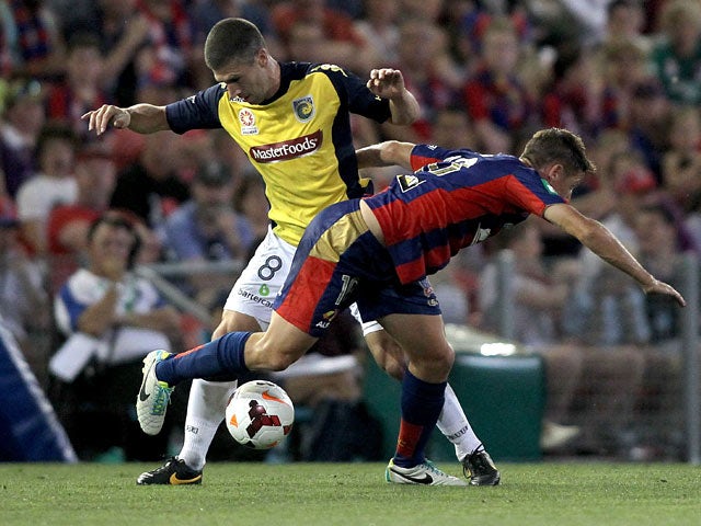 Central Coast Mariners' Nick Montgomery and Newcastle Jets' Connor Chapman battle for the ball during their A-League match on November 2, 2013
