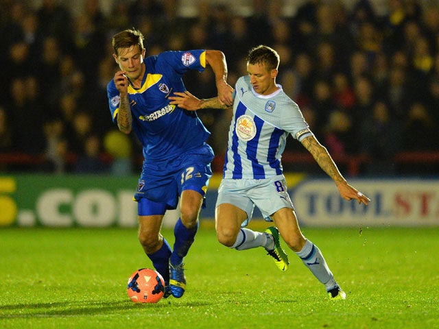 Harry Pell of AFC battles with Carl Baker of Coventry during the FA Cup First Round match between AFC Wimbledon and Coventry City at The Cherry Red Records Stadium on November 8, 2013