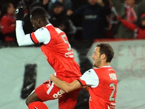 Valenciennes's Benjamin Angoua is congratulated by a teammate after scoring a goal during the French L1 football match against Montpellier on November 9, 2013