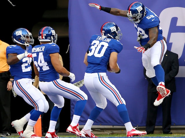 Cooper Taylor of the New York Giants celebrates his touchdown with Allen Bradford after he scored with a blocked punt in the first quarter against the Oakland Raiders on November 10, 2013