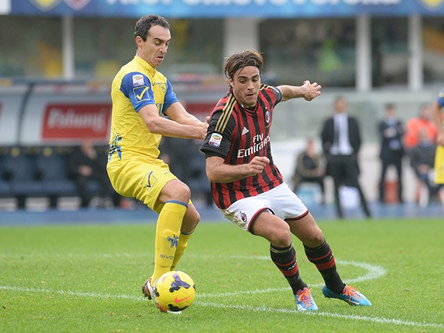 Chievo Verona's Dario Dainelli and AC Milan's Alessandro Matri battle for the ball on November 10, 2013