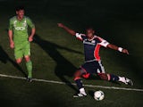 Kalifa Cisse #4 of the New England Revolution kicks the ball under pressure from Brad Evans of the Seattle Sounders during the first half of the FC Tucson Desert Diamond Cup at Kino Sports Complex on February 13, 2013