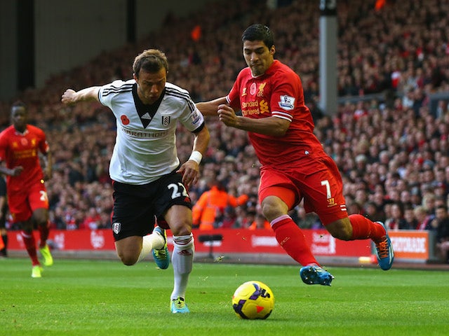 Luis Suarez of Liverpool competes with Elsad Zverotic of Fulham during the Barclays Premier League match between Liverpool and Fulham at Anfield on November 9, 2013