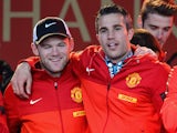 Manchester United's Dutch striker Robin van Persie and English striker Wayne Rooney celebrate on stage after winning the Premier League title for the 13th time, during the team's victory parade outside the town hall in Manchester, north west England, on M