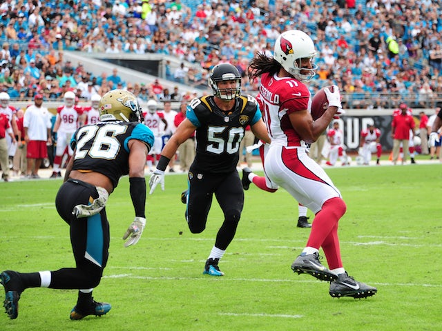 Larry Fitzgerald of the Arizona Cardinals makes a catch for a touchdown against Josh Evans and Russell Allen of the Jacksonville Jaguars on November 17, 2013