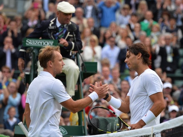 Rafael Nadal and Steve Darcis embrace at the net after the latter wins their match at Wimbledon on June 24, 2013.