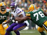 Adrian Peterson of the Minnesota Vikings is hit by Mike Daniels of the Green Bay Packers at Lambeau Field on November 24, 2013