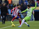 Atletico Madrid's Arda Turan vies with Getafe's Michel during the Spanish League football match on November 23, 2013