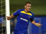 Charlie Strutton of AFC Wimbledon celebrates his second goal during the FA Cup First Round Replay between AFC Wimbledon and York City at The Cherry Red Records Stadium on November 12, 2012