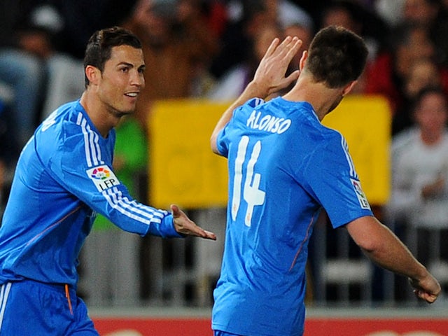 Real Madrid's Portuguese forward Cristiano Ronaldo celebrates with his teammate midfielder Xabi Alonso after scoring during the Spanish league football match against UD Almeria on November 23, 2013