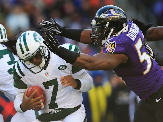 Quarterback Geno Smith of the New York Jets is hit by outside linebacker Elvis Dumervil of the Baltimore Ravens during the first half at M&T Bank Stadium on November 24, 2013