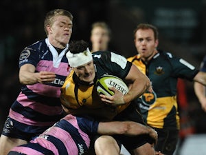 Glenn Dickson of Northampton Saints tackled by Ollie Thorley and Charlie Sharples of Gloucester during the LV= Cup match between Northampton Saints and Gloucester at Franklin's Gardens on November 9, 2013 