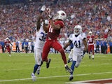 Wide receiver Larry Fitzgerald of the Arizona Cardinals catches a touchdown reception past cornerback Cassius Vaughn strong safety Antoine Bethea of the Indianapolis Colts on November 24, 2013