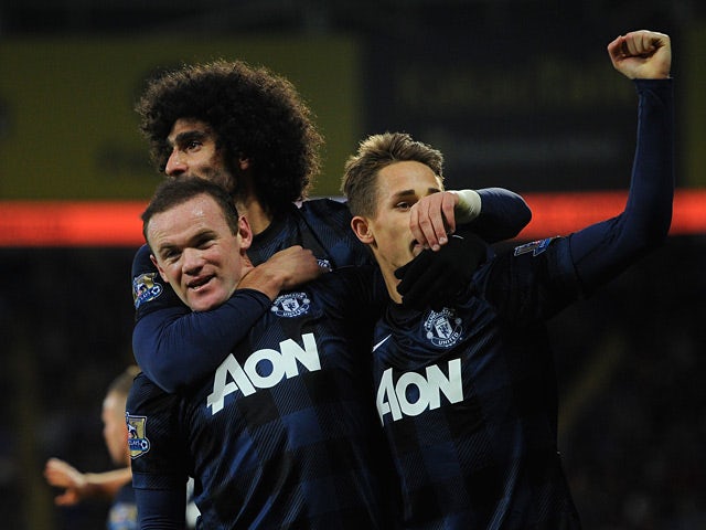 Man United's Wayne Rooney is congratulated by teammates after scoring the opening goal against Cardiff on November 24, 2013