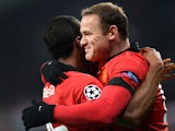 Man United's Antonio Valencia is congratulated by teammates Wayne Rooney after scoring the opening goal against Bayern Leverkusen during their Champions League group match on November 27, 2013