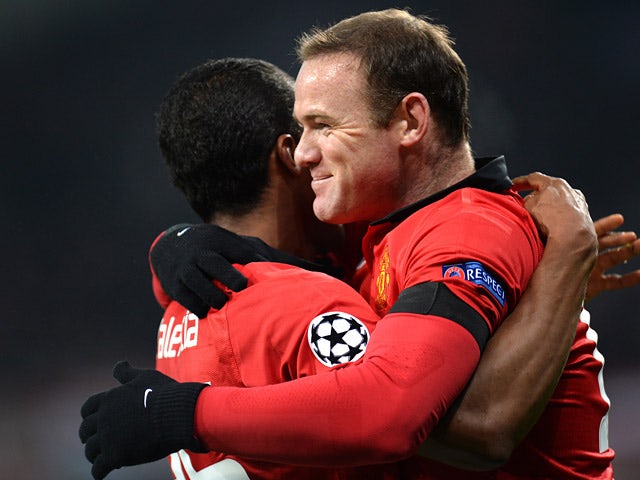 Man United's Antonio Valencia is congratulated by teammates Wayne Rooney after scoring the opening goal against Bayern Leverkusen during their Champions League group match on November 27, 2013
