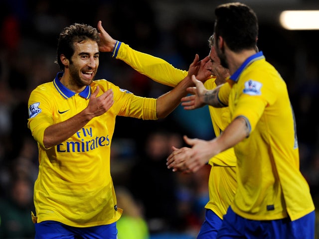 Mathieu Flamini of Arsenal celebrates with Olivier Giroud and Nacho Monreal  as he scores their second goal during the Barclays Premier League match between Cardiff City and Arsenal at Cardiff City Stadium on November 30, 2013