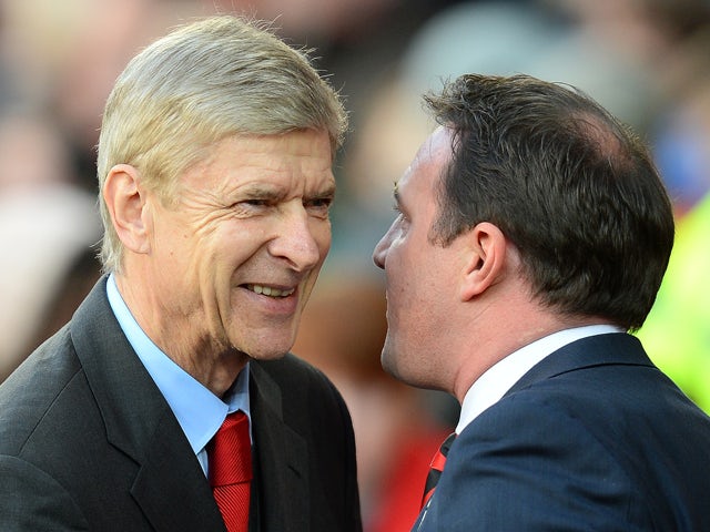 Arsenal's French manager Arsene Wenger chats with Cardiff City manager Malky Mackay before the English Premier League football match between Cardiff City and Arsenal at The Cardiff City stadium in Cardiff, south Wales on November 30, 2013