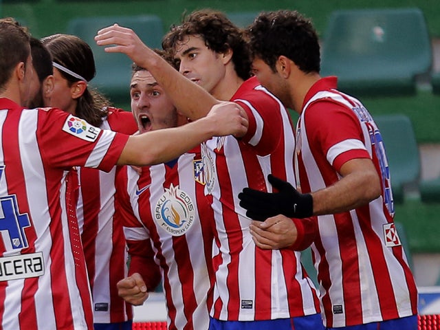 Atletico Madrid's midfielder Koke celebrates with his teammates after scoring during the Spanish league football match Elche vs Club Atletico de Madrid at the Manuel Martinez Valero Stadium in Elche on November 30, 2013