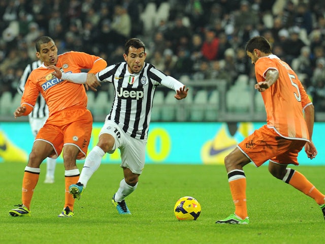 Carlos Tevez of Juventus is challenged by Allan Marques of Udinese Calcio during the Serie A match between Juventus and Udinese Calcio at Juventus Arena on December 1, 2013