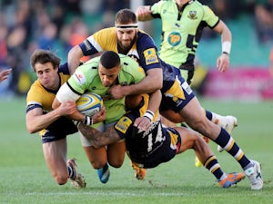Luther Burrell of Northampton Saints is tackled by Ignacio Mieres, Sam Betty and James Stephenson of Worcester Warriors during the Aviva Premiership match on November 30, 2013